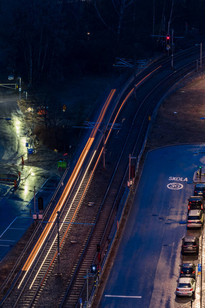 Estocolmo, Suecia Un tranvía por la noche y en la lluvia pasan por el distrito de Arstadal. - Foto, Imagen