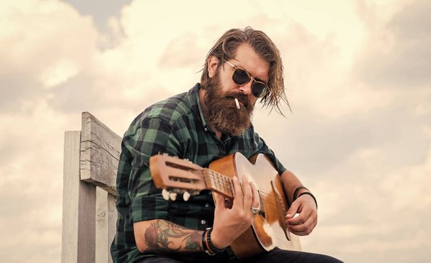 music concept. brutal handsome man with moustache play guitar. mature musician and singer. casual styled guitarist. modern looking bearded hipster with acoustic guitar. Beat droppers - Foto, immagini