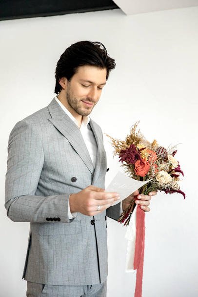 The groom reads the wedding vow to the bride with a bouquet in his hands. High quality photo - Foto, immagini