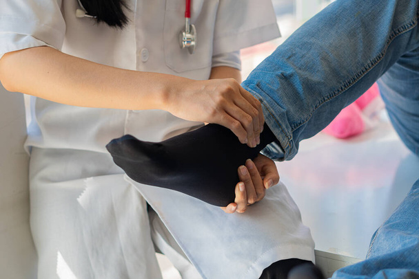 Physiotherapiekonzept Bild eines jungen Mannes mit verletztem Bein, der Arzt massiert Patient Bein, der medizinische Behandlung für verstauchtes Band Das Konzept der Rehabilitation nach einer Beinverletzung. - Foto, Bild