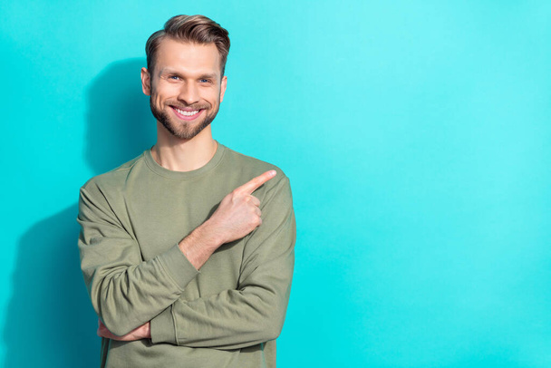 Photo of cheerful confident promoter man direct finger empty space wear pullover isolated blue color background - Fotoğraf, Görsel