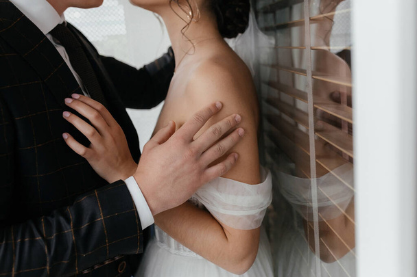 El novio acaricia el delicado hombro de la novia. Foto de alta calidad - Foto, Imagen