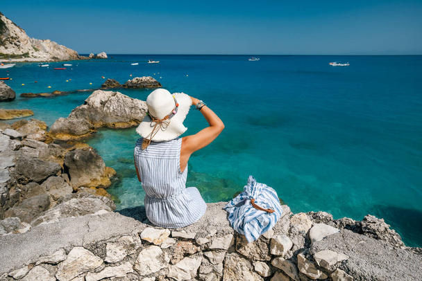 A tourist woman with hat enjoy ionian sea in Agios Nikitas village, Lefkas Island, Greece. - Fotografie, Obrázek