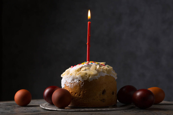 Пасхальний торт зі свічкою та розфарбованими яйцями
 - Фото, зображення