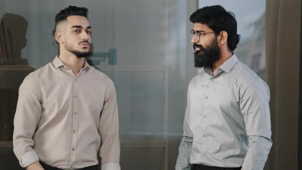 Dois amigos do sexo masculino multirracial diversos colegas parceiros de negócios hispânico homem árabe barbudo cara de pé no escritório posando com cruzados braços acenando concordar cabeça olhando para câmera confiante colegas de trabalho - Filmagem, Vídeo