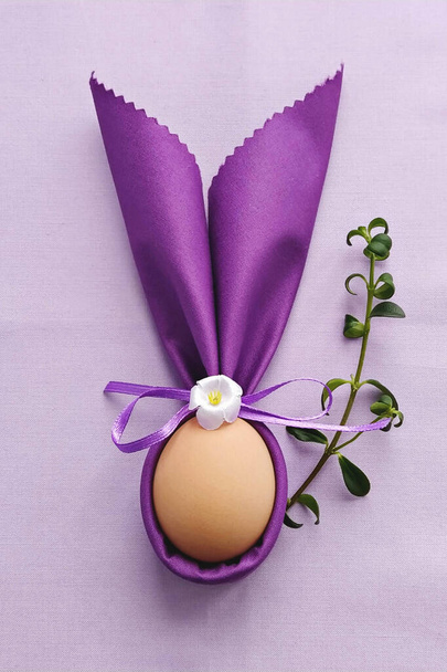 イースター、 DIY 、フラットレイアウトを祝うために紫色の綿のテーブルクロスに卵と装飾的なバニーの耳 - 写真・画像