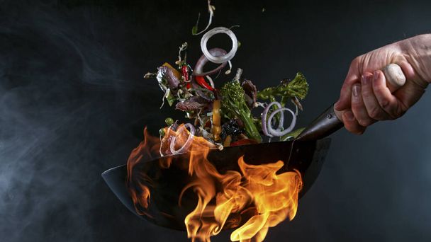 Freeze Motion of Wok Pan and Flying Ingredients in the Air. - Foto, imagen
