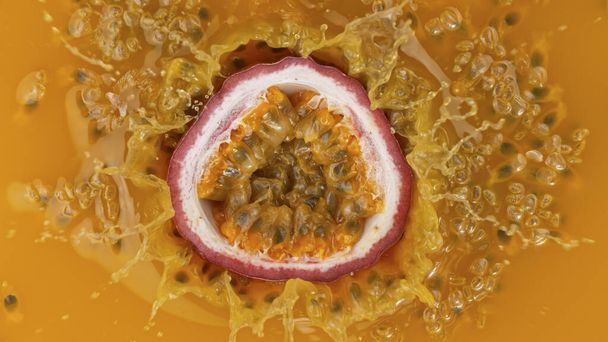 Fresh sliced passion fruit falling into juice - Фото, зображення