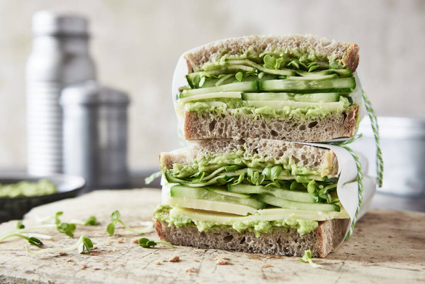 sandwich with avocado, cucumber and lettuce on white plate - Fotoğraf, Görsel