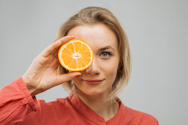 portret z połową pomarańczy, naturalne piękno i pielęgnacja - Zdjęcie, obraz
