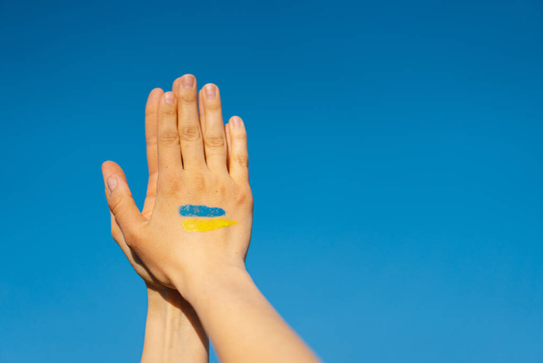 Mulher mãos com símbolo da bandeira ucraniana orando para parar a guerra na Ucrânia - Foto, Imagem