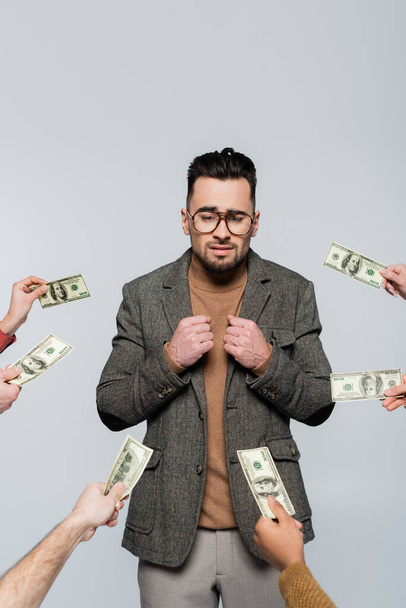 сором'язливий критик в окулярах біля людей з доларовими банкнотами ізольовані на сірому
 - Фото, зображення