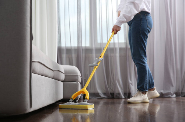 Woman cleaning parquet floor with mop indoors, closeup - Foto, imagen