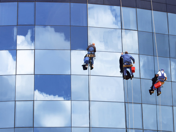 werknemers een wolkenkrabber windows wassen - Foto, afbeelding