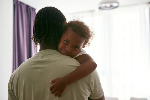 Black father hold and hug daughter in arms at home - Фото, изображение