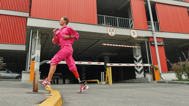 Athlete girl with artificial leg running in city - Zdjęcie, obraz