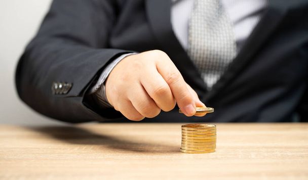 Бізнесмен закладає золоті монети в шари майбутньої теорії планування фінансових інвестицій
 - Фото, зображення