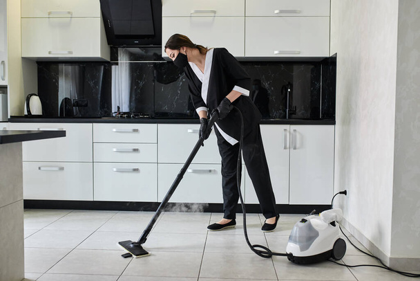 Úklidová společnost zaměstnanec odstraňování nečistot z podlahy v kuchyni s profesionální parní čistič zařízení - Fotografie, Obrázek