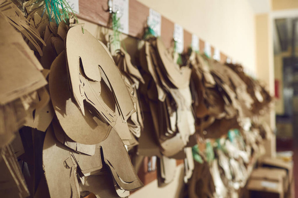 Closeup shot of sewing patterns for shoe details hanging on peg rack at footwear factory - Foto, Imagen