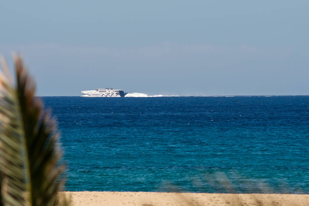 Ios, Grecia - 16 de mayo de 2021: Un ferry que pasa frente a la famosa playa de Mylopotas en Ios Grecia - Foto, imagen