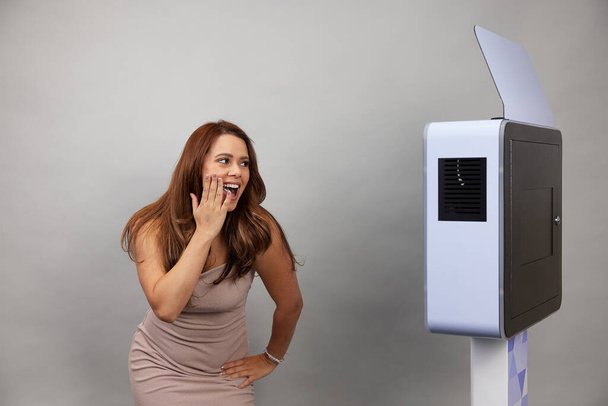 female posing in front of a white photo booth - Foto, Imagen