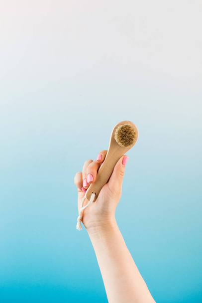 Exfoliating dry facial brush made of natural bristles in a womans hand. Peeling, detox for the skin of the face. - Foto, imagen