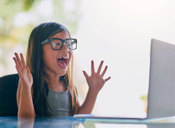 La tecnología la excita. Recortado disparo de una niña pequeña mirando emocionado mientras se utiliza un ordenador portátil. - Foto, Imagen