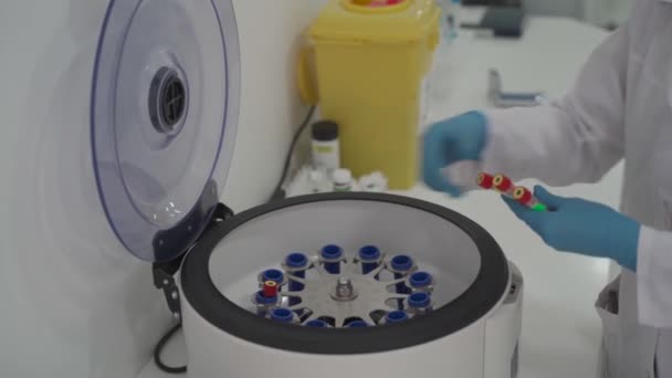 Platelet-Rich plasma preparation. Tube with blood in hands. Centrifuge. Doctor or lab technician putting blood samples in centrifuge - Footage, Video