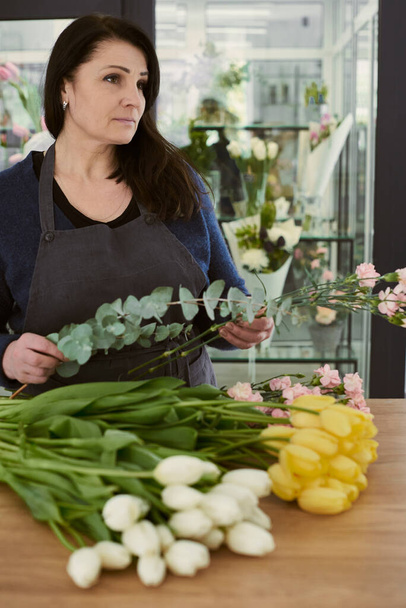 beautiful young florist makes a bouquet - Photo, Image