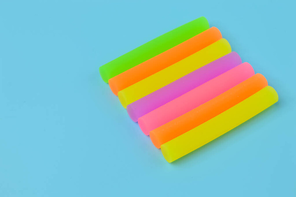 Various colorful erasers isolated on a blue background - Фото, изображение