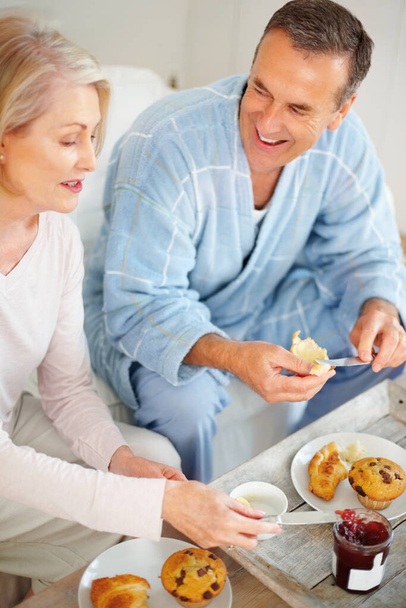 Cheerful mature man and his wife having breakfast. Portrait of a cheerful mature man and his wife having breakfast. - Foto, immagini