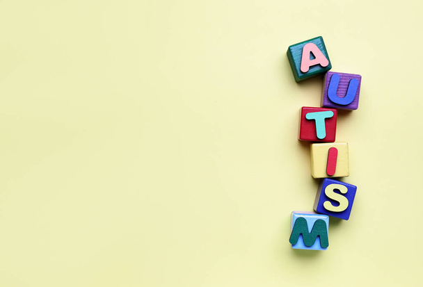 Кубики зі словом AUTISM на бежевому фоні
 - Фото, зображення