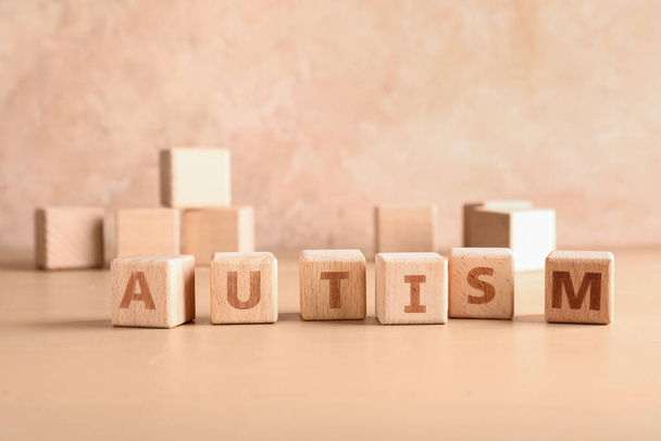 Wooden cubes with word AUTISM on color background - Foto, Imagem