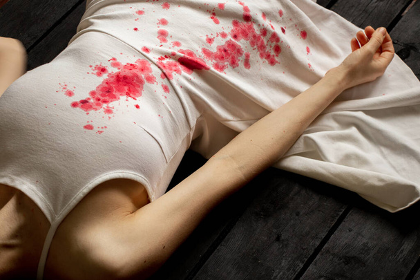 Uma mulher ucraniana assassinada e torturada com um vestido branco e manchas de sangue jaz no chão da casa, uma ação de protesto por mulheres ucranianas, protegendo as mulheres dos soldados russos. - Foto, Imagem