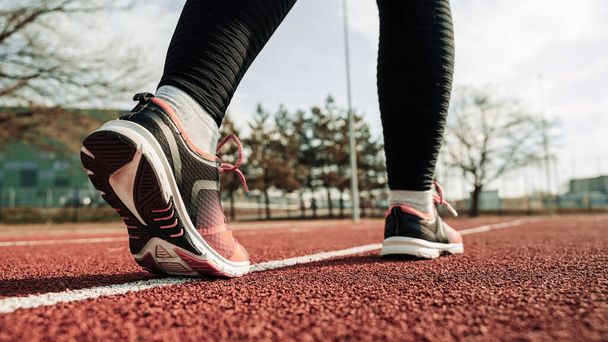 Spor koşucusu kız eğitimi. Kadın egzersizi yap. Koşan ayaklar yolda, ayakkabıya yakın gidiyor. Fitness, spor, yaşam tarzı konsepti - Fotoğraf, Görsel