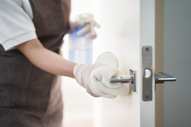 Asian woman sterilizing door handles with alcohol - 写真・画像