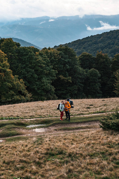 Tourists walk through the Ukrainian Carpathians, tourists carry heavy backpacks on their backs, mountain trail to Mount Petros. - Fotó, kép