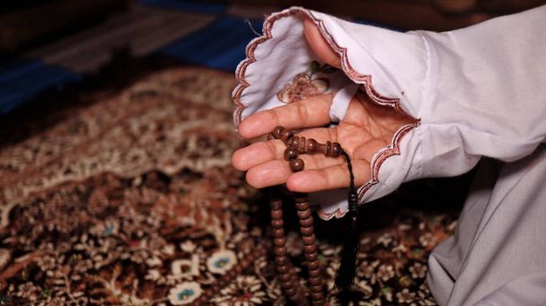 Mulheres muçulmanas fazendo dhikr com contas de oração em tapetes de oração solenemente - Foto, Imagem