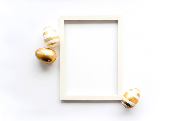 Gold white eggs on a white background with space for copy space for text in a frame. Minimal concept. View from above. Easter card, soft selective focus. - Foto, imagen