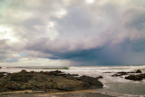 Kiezelstrand bij Forster, NSW Australië met onweerswolken op afstand - Foto, afbeelding