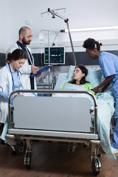 Equipo de médicos que presenta opciones de tratamiento al paciente con enfermedad pulmonar mientras recibe atención médica - Foto, imagen