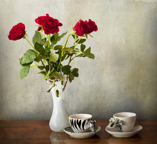 Espresso für zwei Personen und eine Vase mit roten Rosen auf einem Holztisch - Foto, Bild