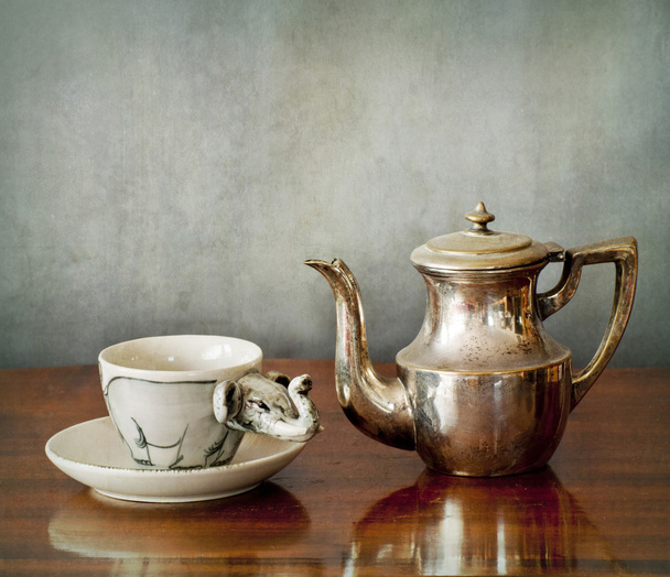 eine Tasse Kaffee und eine Kaffeekanne auf einem Holztisch - Foto, Bild