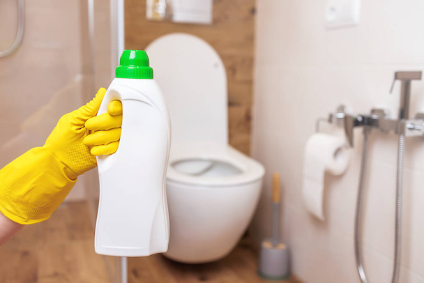 White bottle mockup for toilet sanitizer. Close-up, hand holding bottle of liquid - Fotó, kép