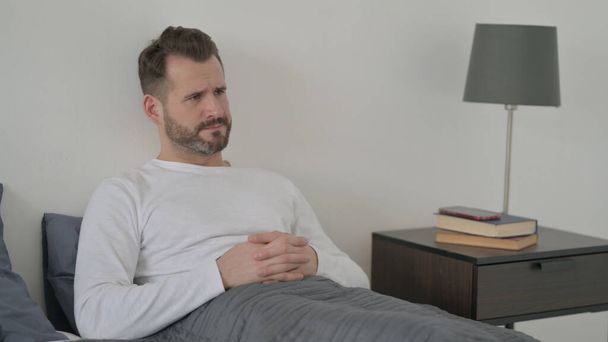 Man Feeling Worried while Sitting in Bed - Foto, afbeelding