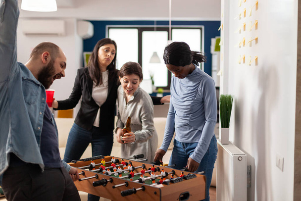 Frustrated woman losing at foosball table game in office - Photo, Image