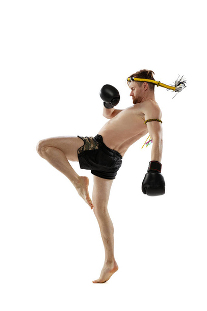 Retrato de boxeador tailandés profesional practicando aislado sobre fondo de estudio blanco. Deporte, muay thai, competición, concepto de club de lucha - Foto, Imagen