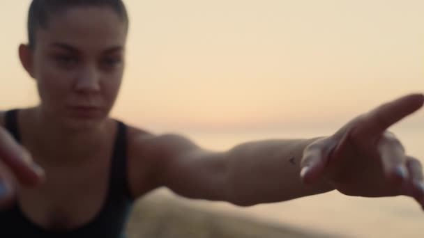 Atrakcyjna twarz sportowa dziewczyna ćwiczy jogę na plaży z bliska. Kobieta ćwicząca. - Materiał filmowy, wideo