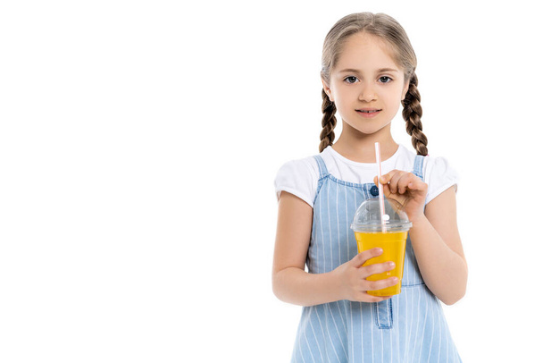 lány fonat és műanyag pohár narancslé nézi kamera elszigetelt fehér - Fotó, kép