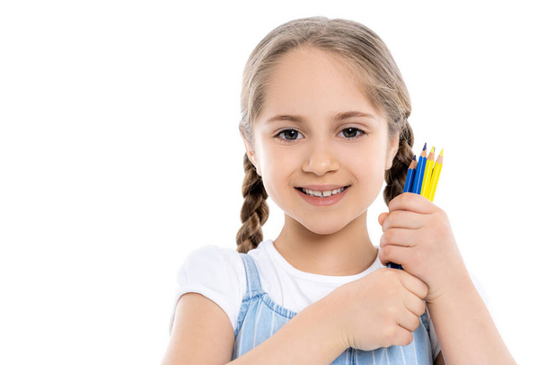 vidám ukrán lány kezében kék és sárga ceruzák elszigetelt fehér - Fotó, kép